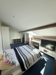 Chambre à l’étage d’un appartement duplex F2 à Thionville Élange avec fenêtre de toit